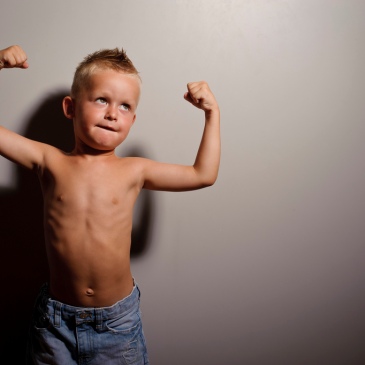 Young boy flexing muscles